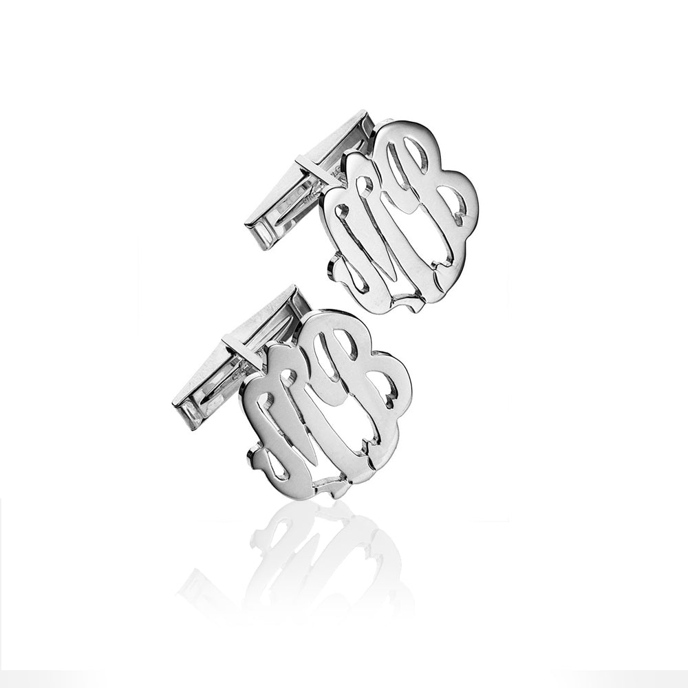 A pair of silver monogram cufflinks featuring the intertwined initials 'MB' in a polished script design, displayed on a clean white background with a soft reflection below.